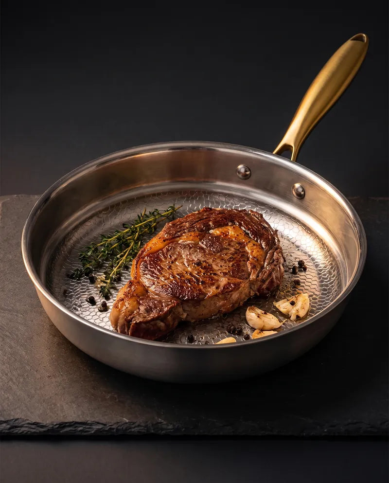 De PFAS-vrije titanium pan met een dichtgeschroeide steak op donkere leisteen