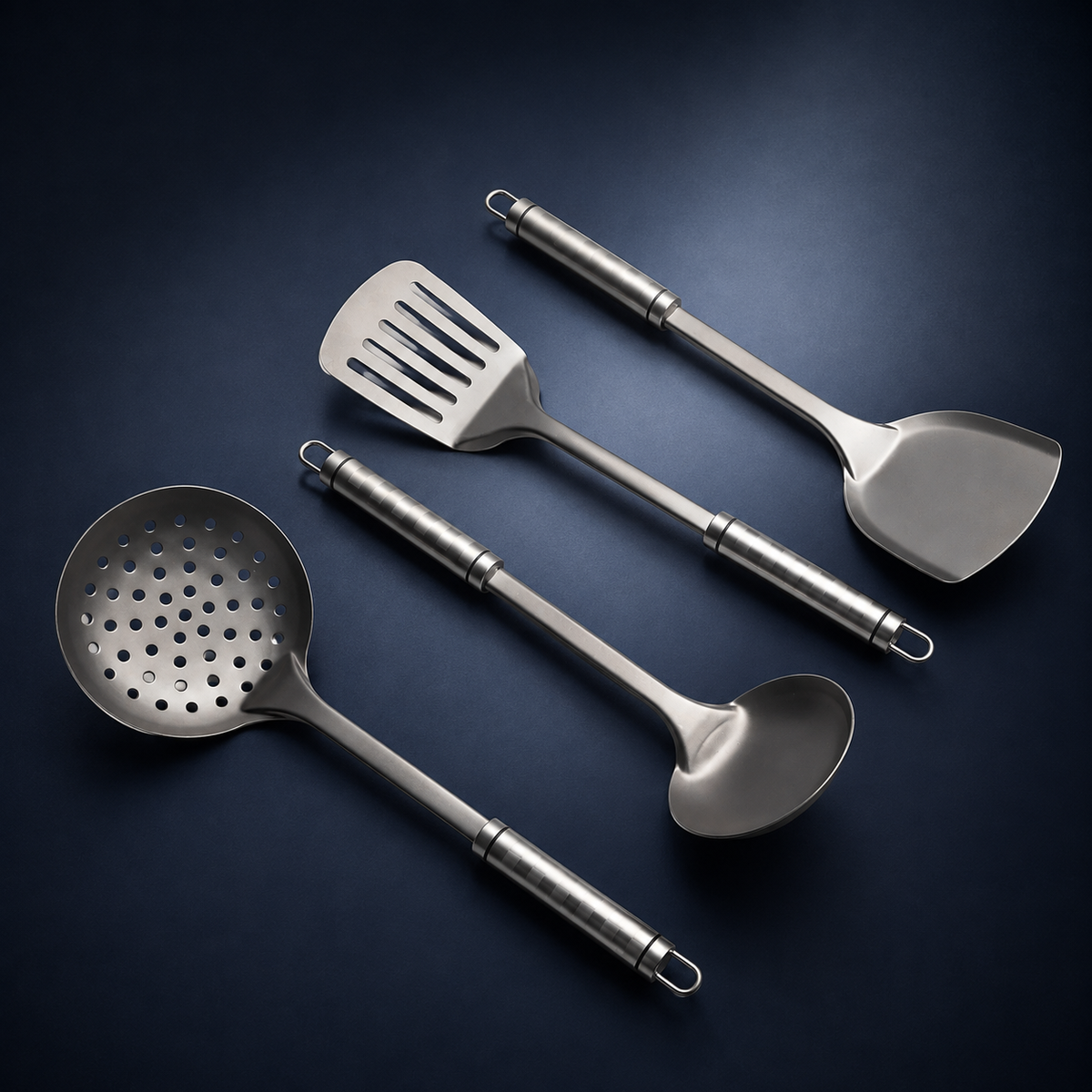 Set de quatre ustensiles de cuisine en titane Maison Ferré® disposés à plat